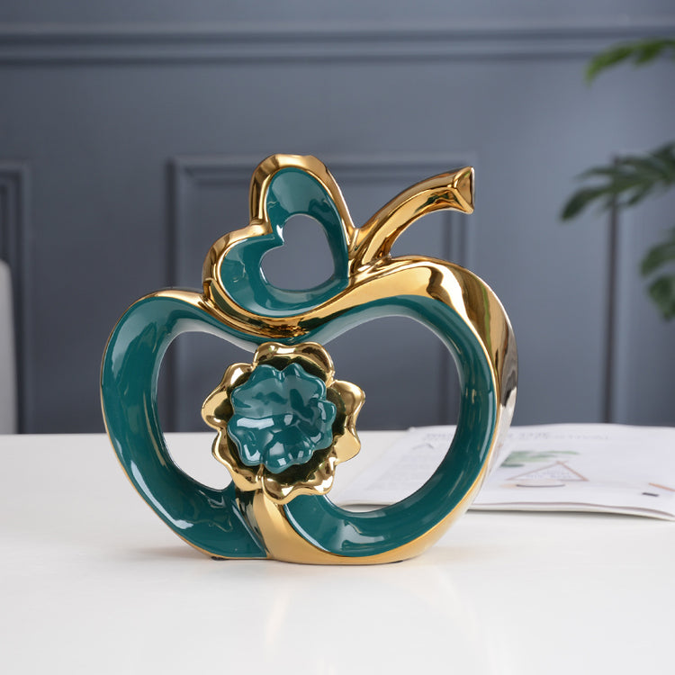 a gold and teal ceramic apple