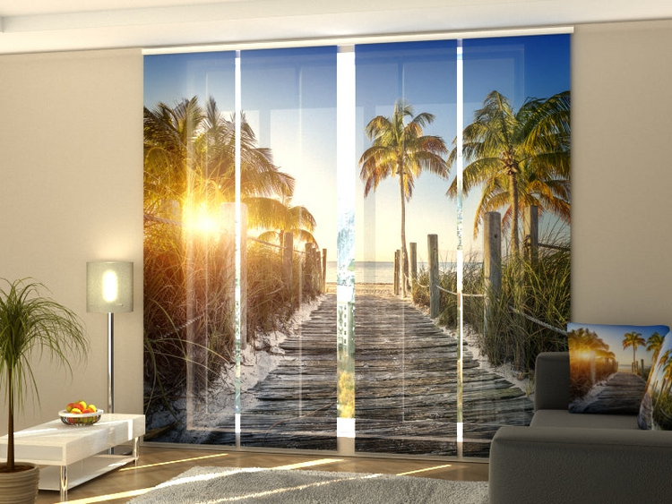 a room with a window with a view of a beach and palm trees