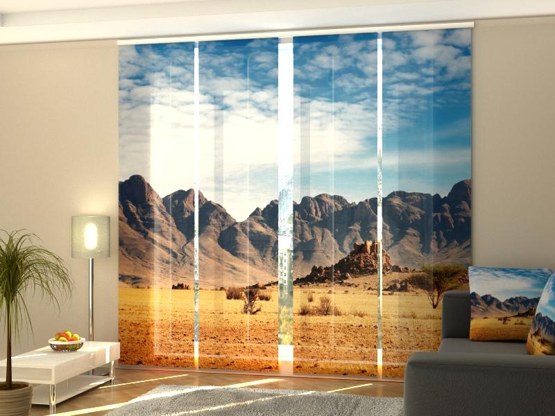 a room with a couch and a window with mountains in the background