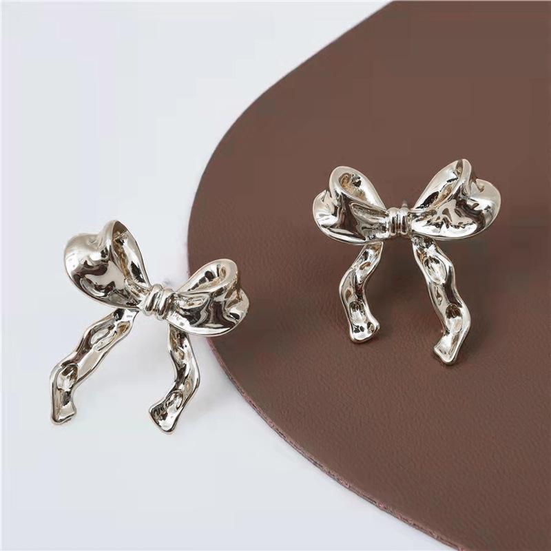 a pair of silver bows on a brown surface