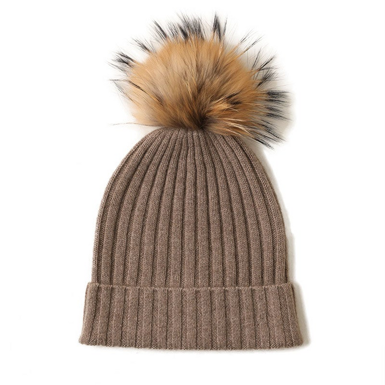 a brown knit hat with a fluffy pom