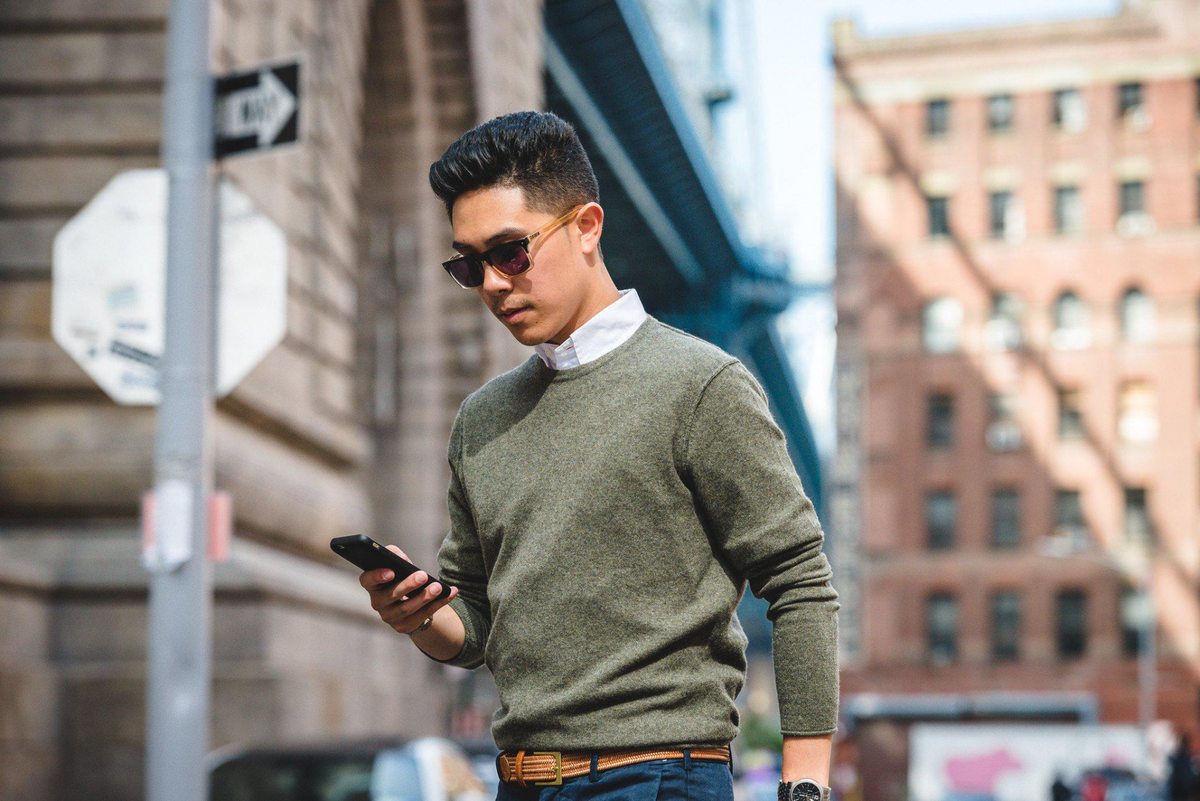 a man walking down the street looking at his phone