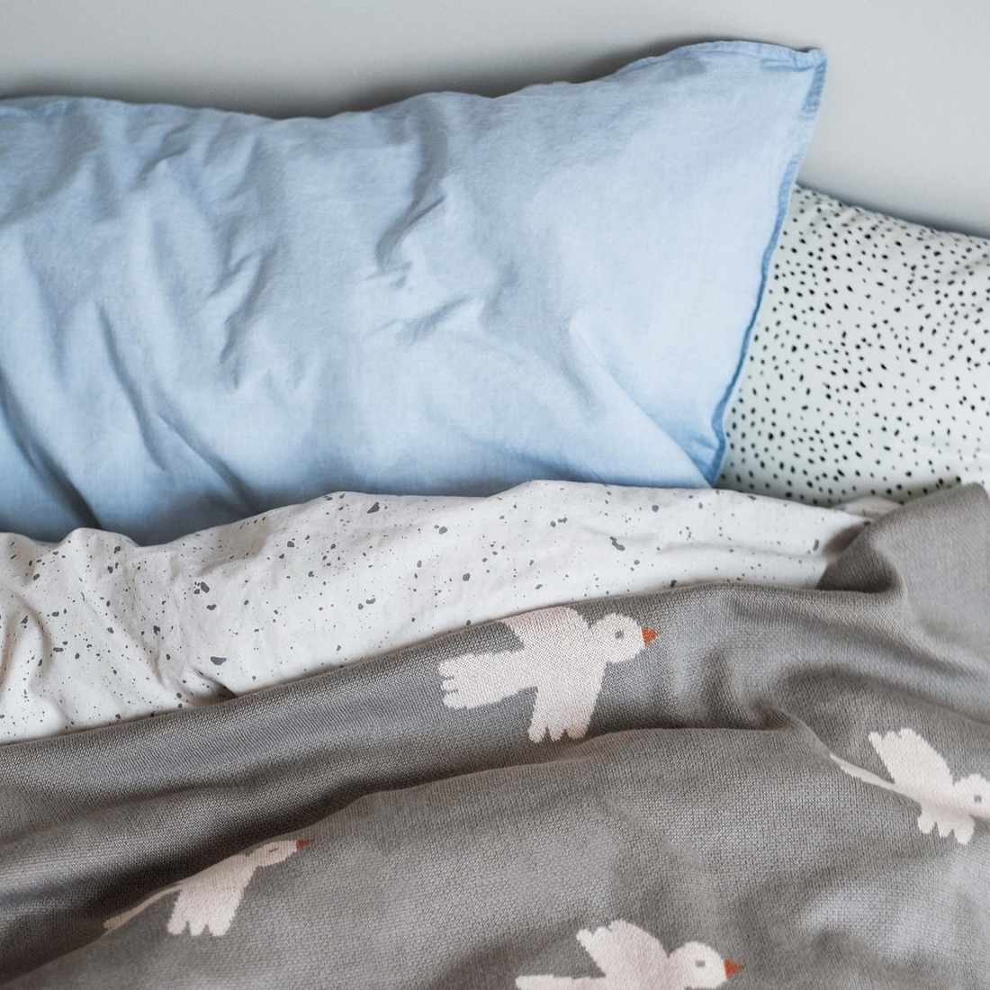 a bed with pillows and blankets