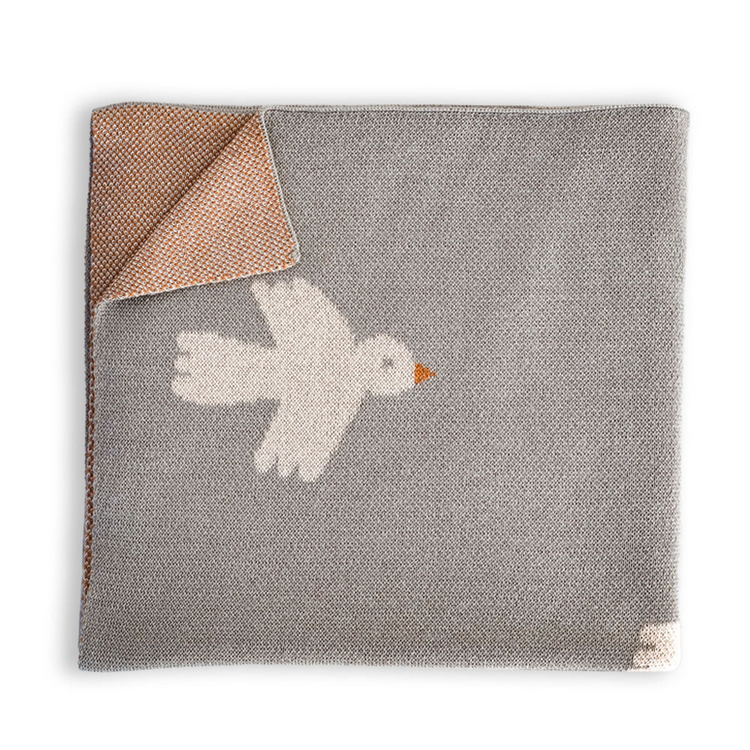 a grey and orange blanket with a bird on it
