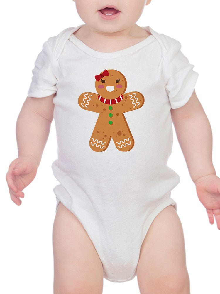a baby wearing a white bodysuit with a gingerbread man on it
