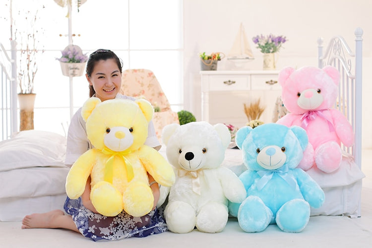 a woman sitting on a bed with several stuffed bears