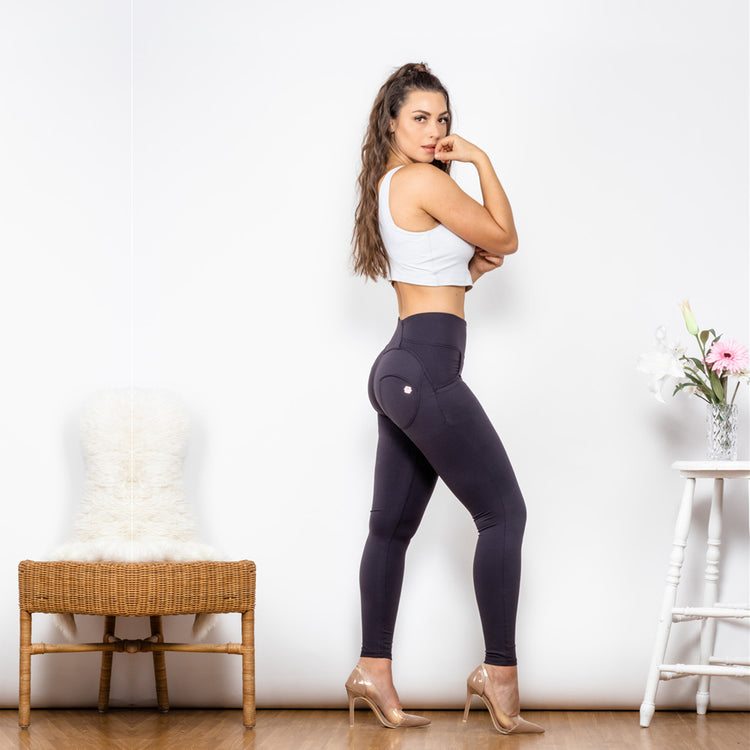 a woman in tight pants and a white tank top