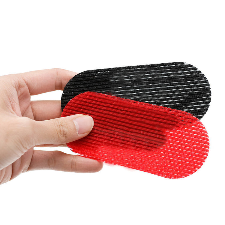 a hand holding a red and black oval object