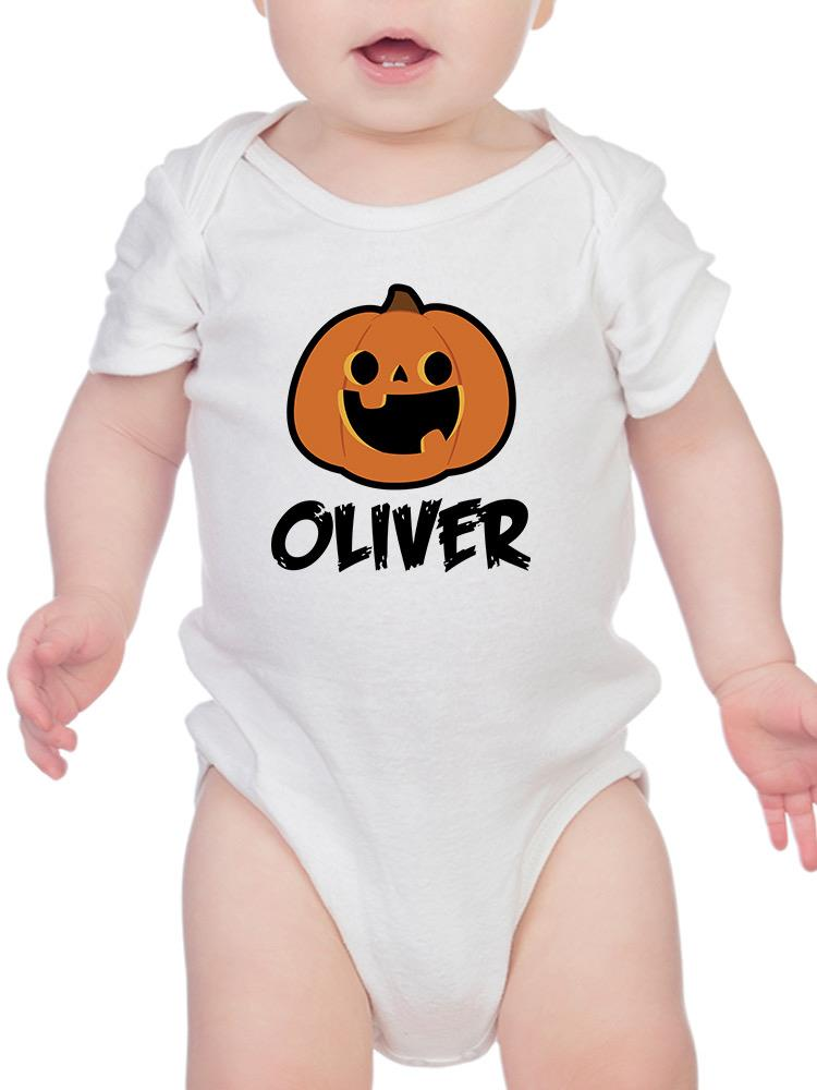 a baby wearing a white bodysuit with a pumpkin on it