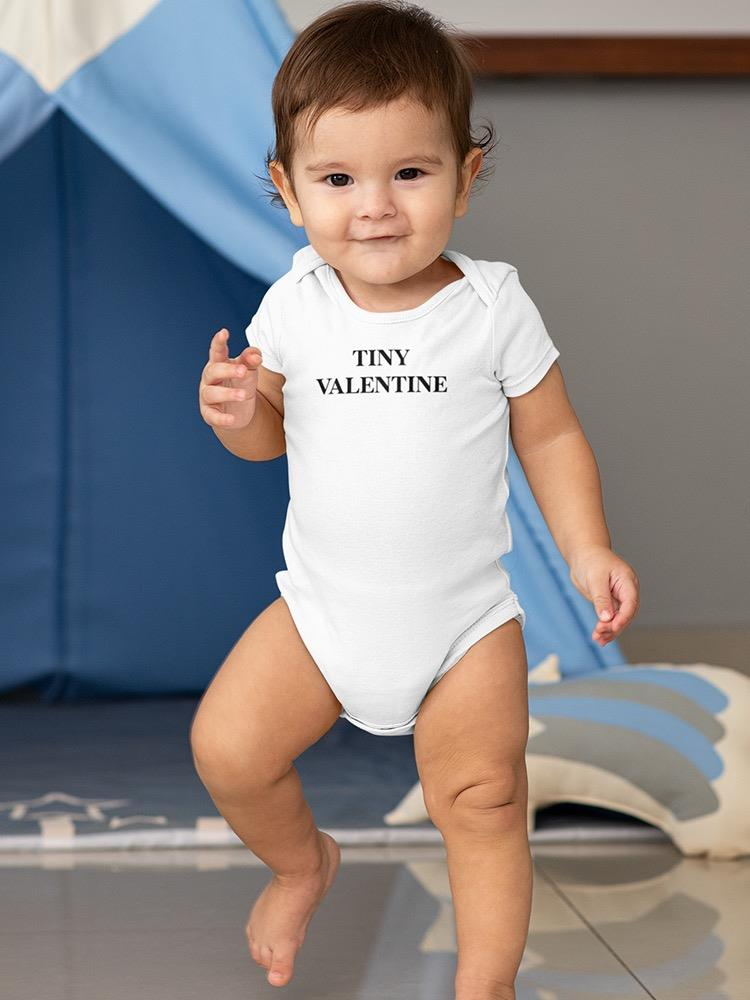 a baby standing in front of a blue tent