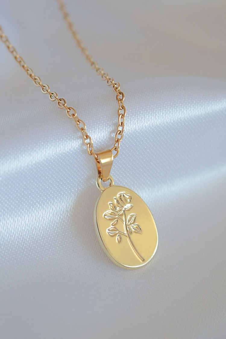 a gold necklace with a flower on it