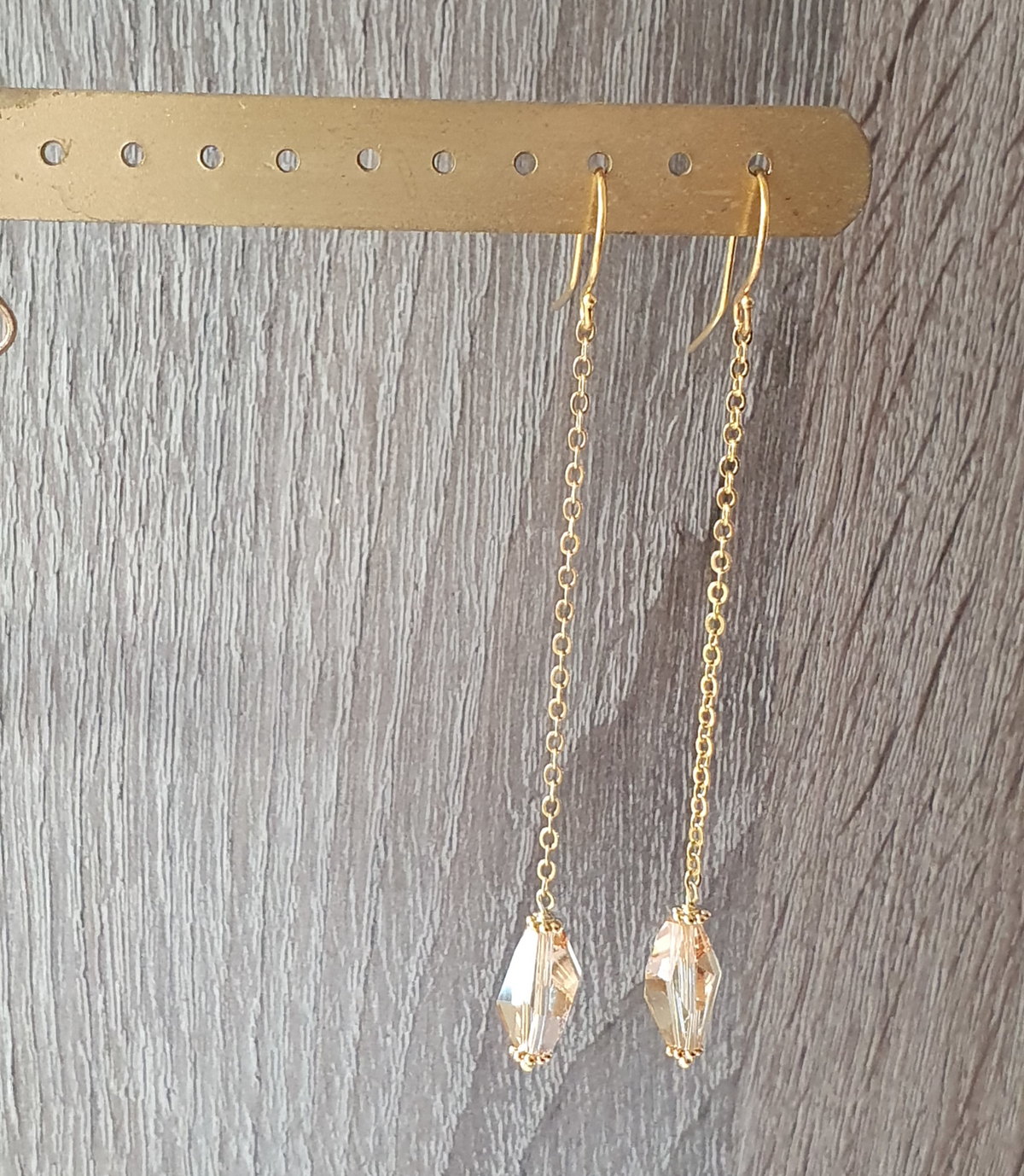 a pair of gold earrings on a bar
