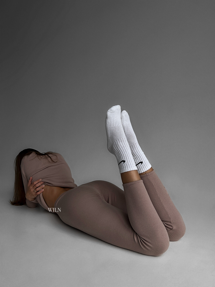 a woman lying on the floor with her legs up