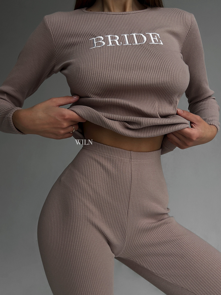 a woman wearing a brown sweater and pants