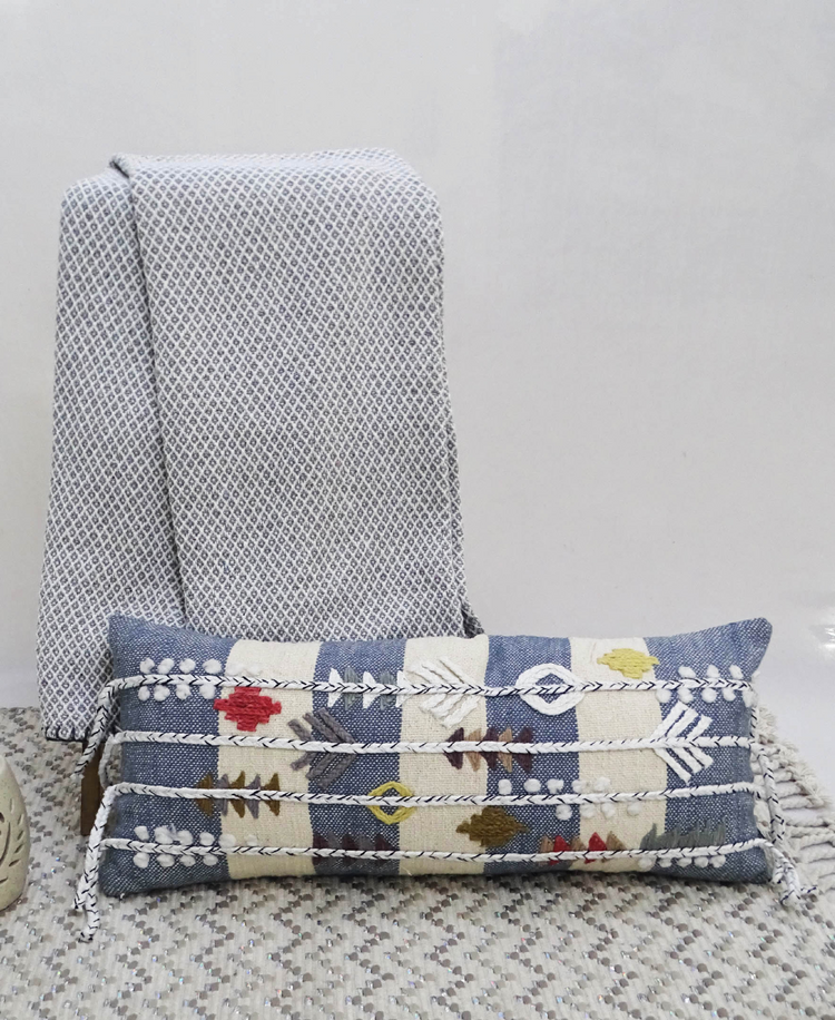 a pillow and blanket on a rug