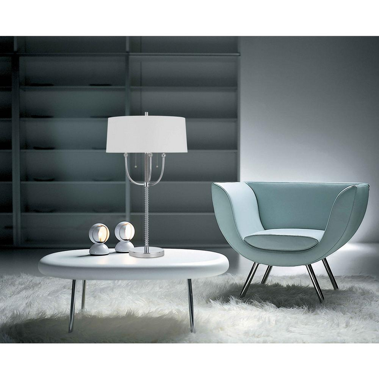 a white round table with a lamp and a blue chair