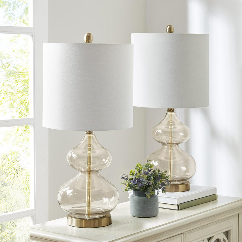a table with two lamps and a vase of flowers