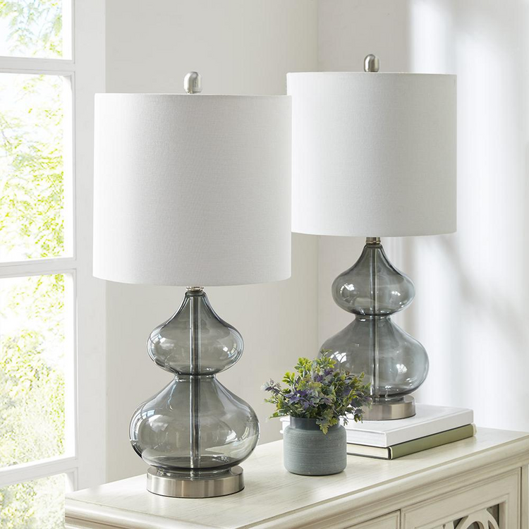 a table with two lamps and a vase of flowers