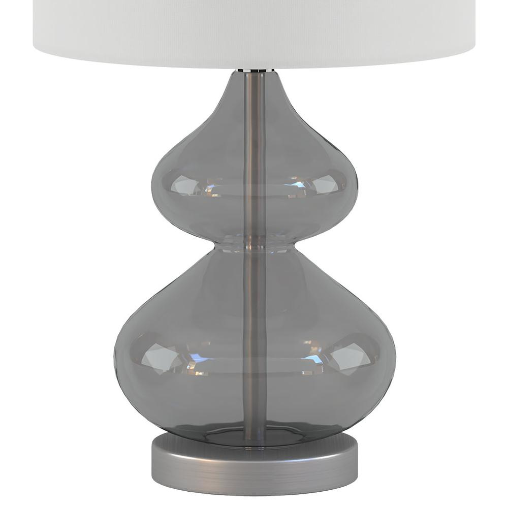 a glass lamp with a white shade