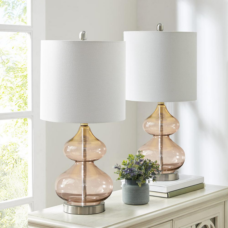 a table with two lamps and a plant on it