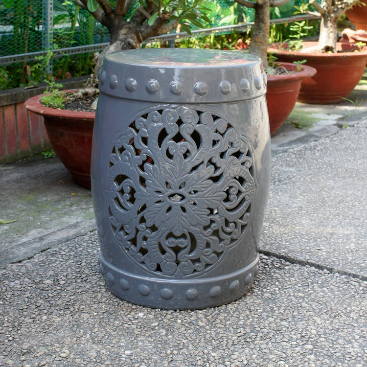 a grey stool with a carved design