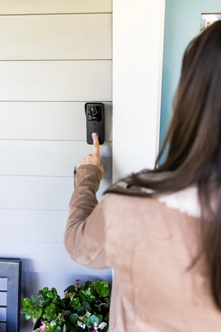 a woman pressing a button on a wall