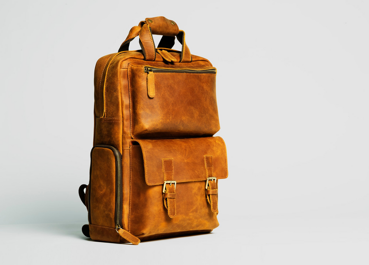 a brown leather backpack with zippers