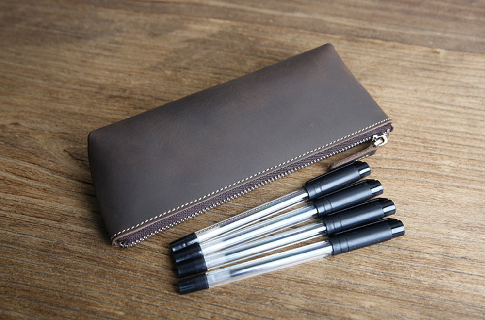 a group of pens next to a zipper case