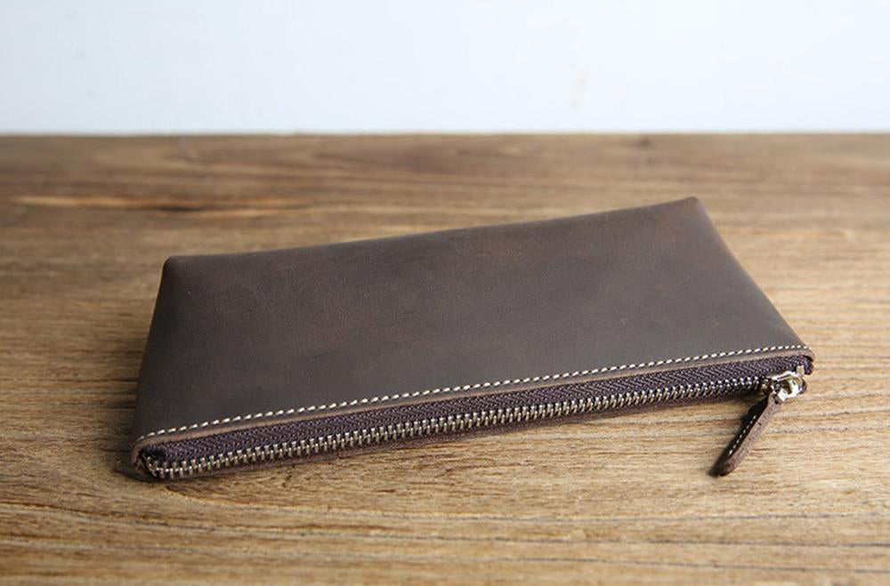 a brown leather wallet on a wood surface
