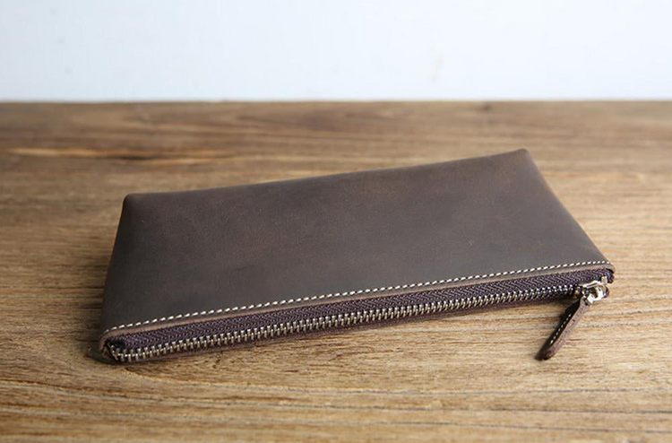 a brown leather wallet on a wood surface