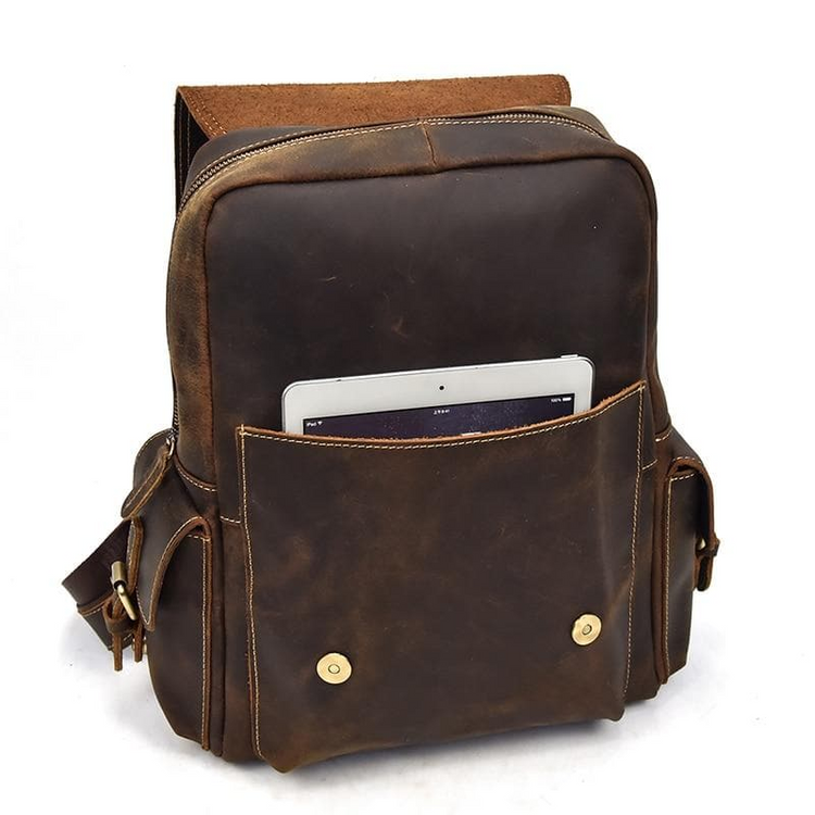 a brown leather backpack with a tablet in it