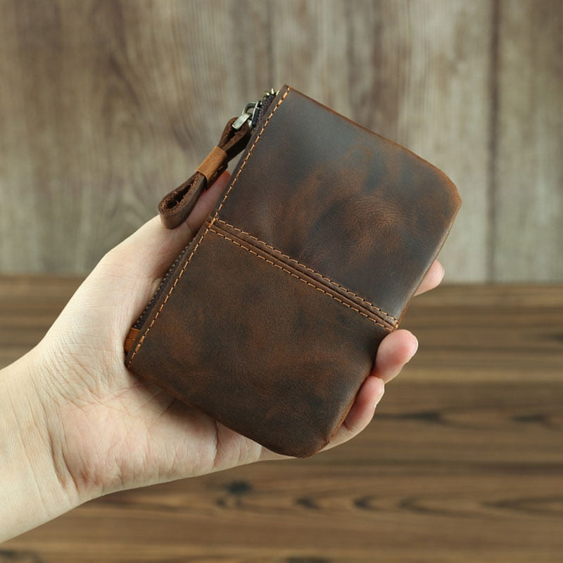 a hand holding a brown wallet