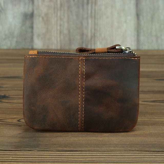 a brown leather wallet on a wood surface