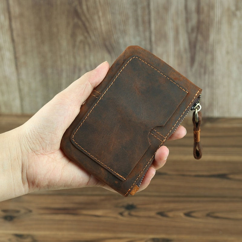 a hand holding a brown wallet