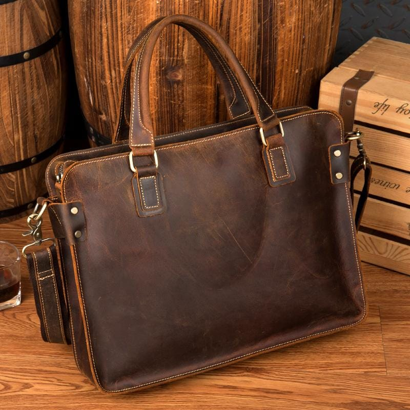 a brown leather bag on a wood surface