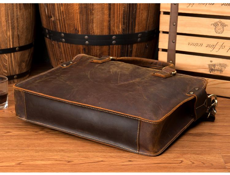 a brown leather briefcase on a wood surface