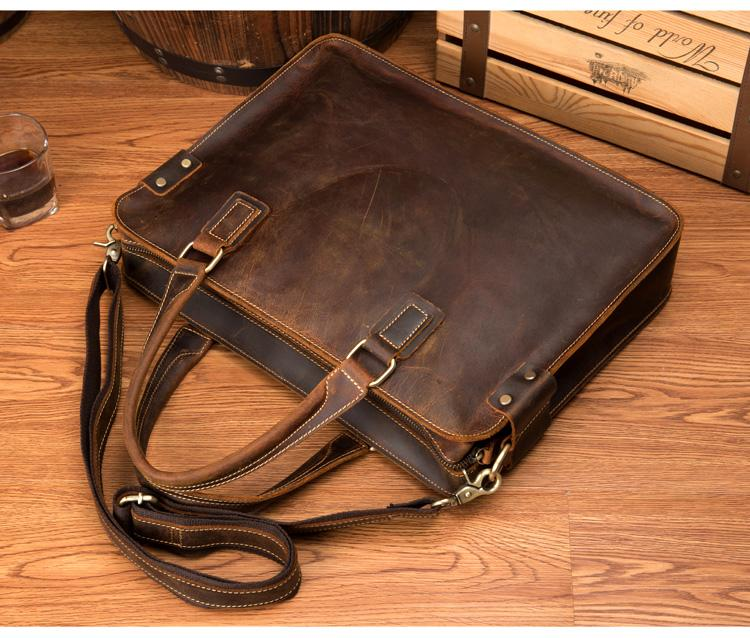 a brown leather bag on a wood surface