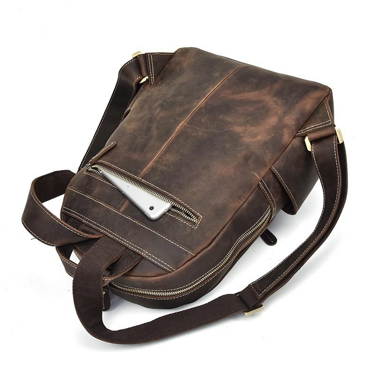 a brown leather bag with a phone in the pocket