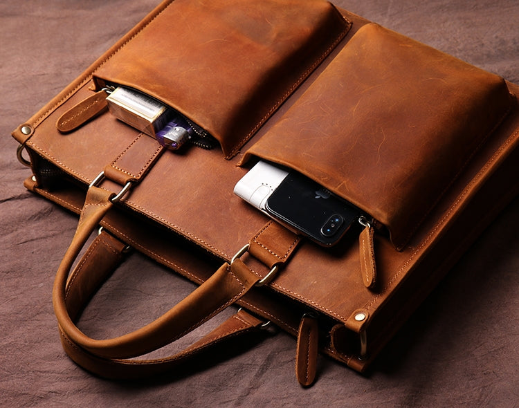 a brown leather bag with a cell phone and lighter inside