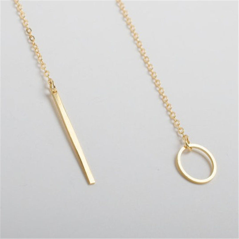 a gold necklace with a bar and a circle