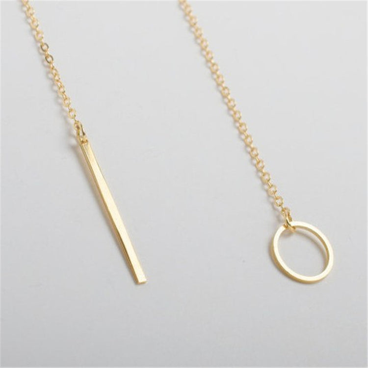 a gold necklace with a bar and a circle