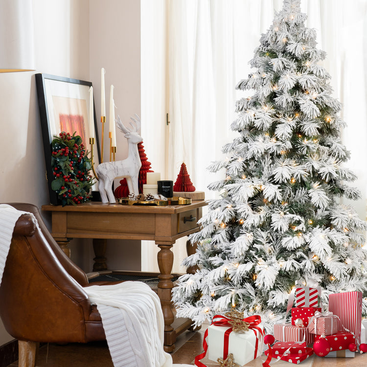 a christmas tree with presents and a chair in a room