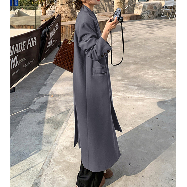 a woman in a long coat holding a camera