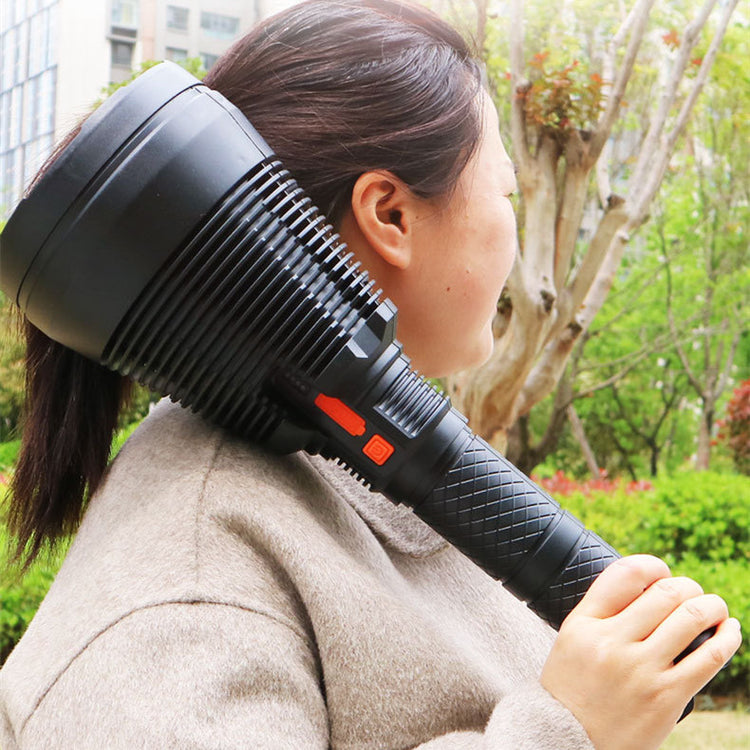 a woman holding a large black flashlight over her head