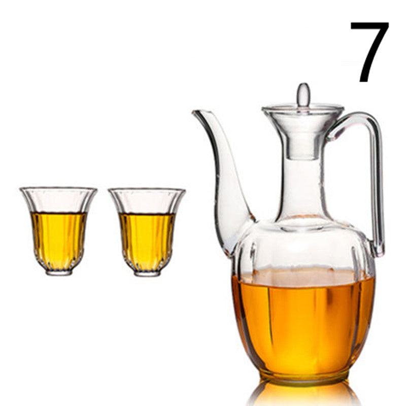 a glass pitcher with a handle and two glasses with yellow liquid