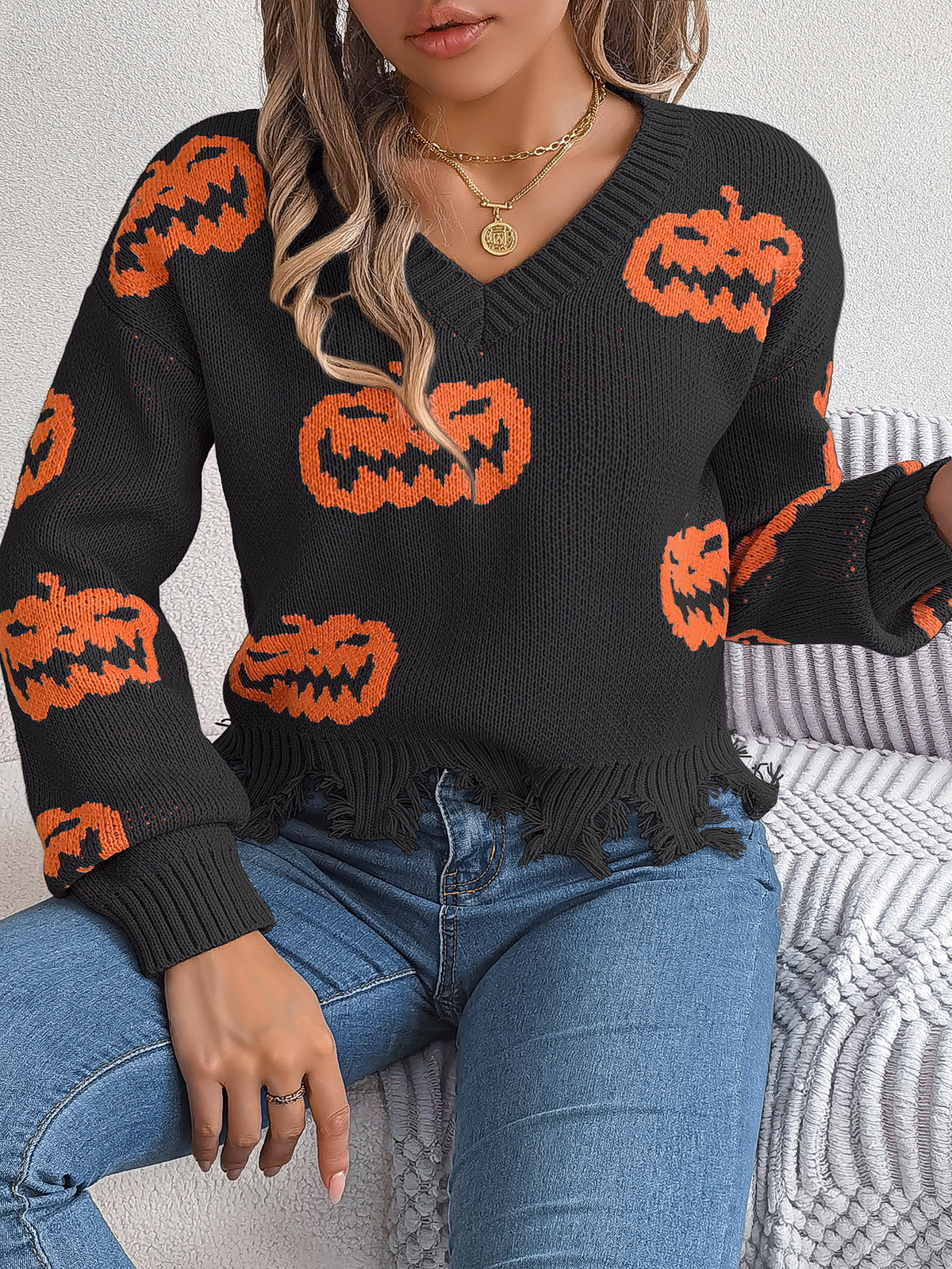 a woman wearing a sweater with pumpkins on it