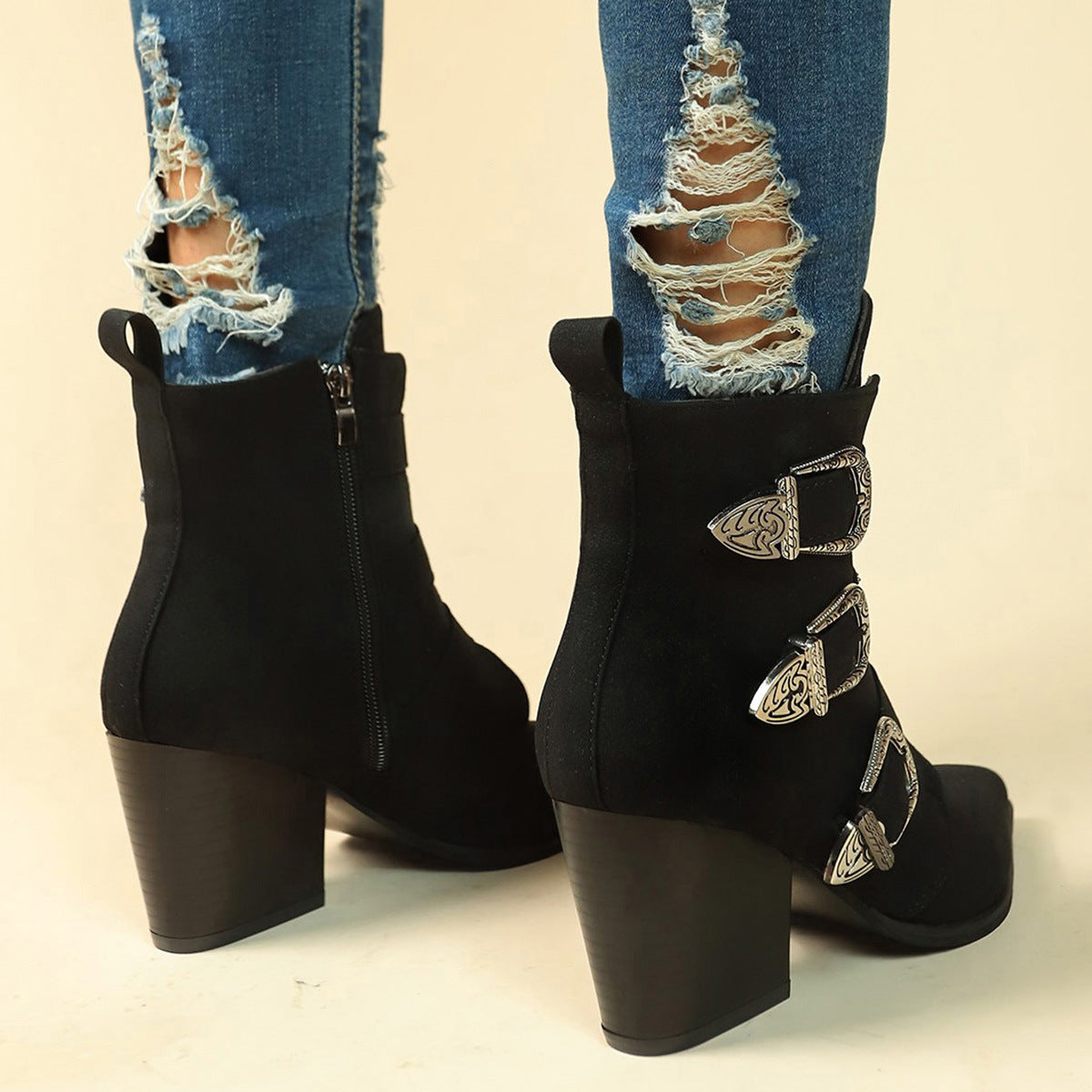 a person wearing ripped jeans and black boots