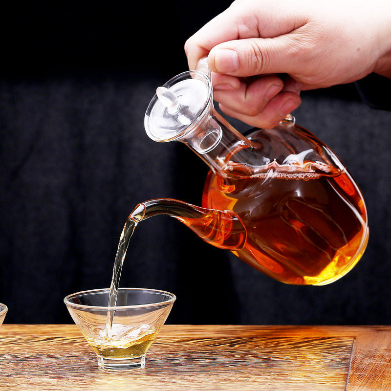 a hand pouring liquid into a glass cup