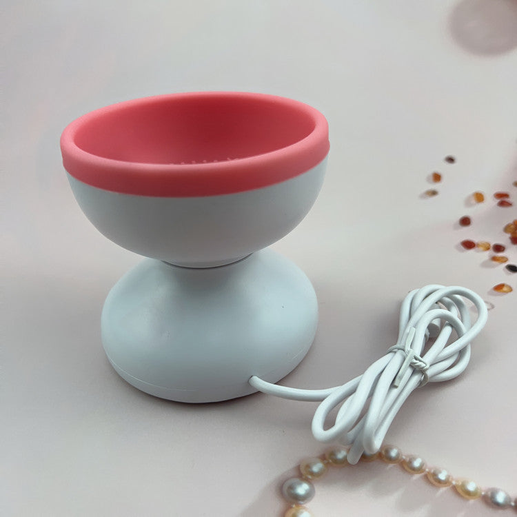 a white and pink device with a cord