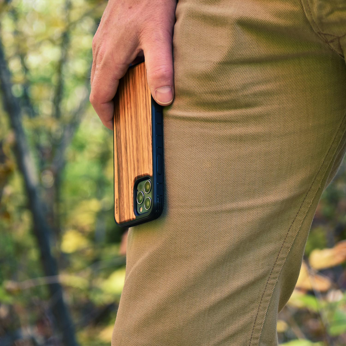 a person holding a phone in their pocket